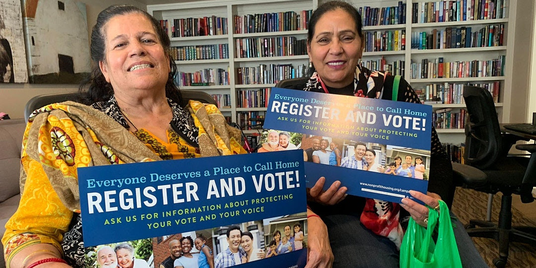 Image of two residents with vote signs.